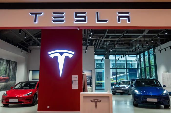 Interior of Tesla showroom with a red Model Y on display.