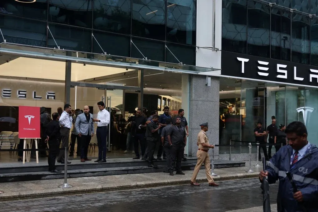 Crowd gathering outside the Tesla showroom in Mumbai in rainy weather.