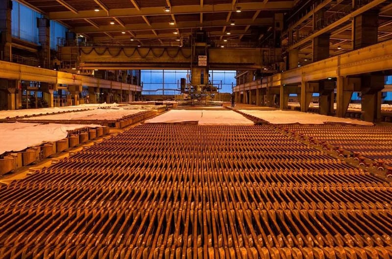 Rows of glowing copper wire rods inside an industrial facility.