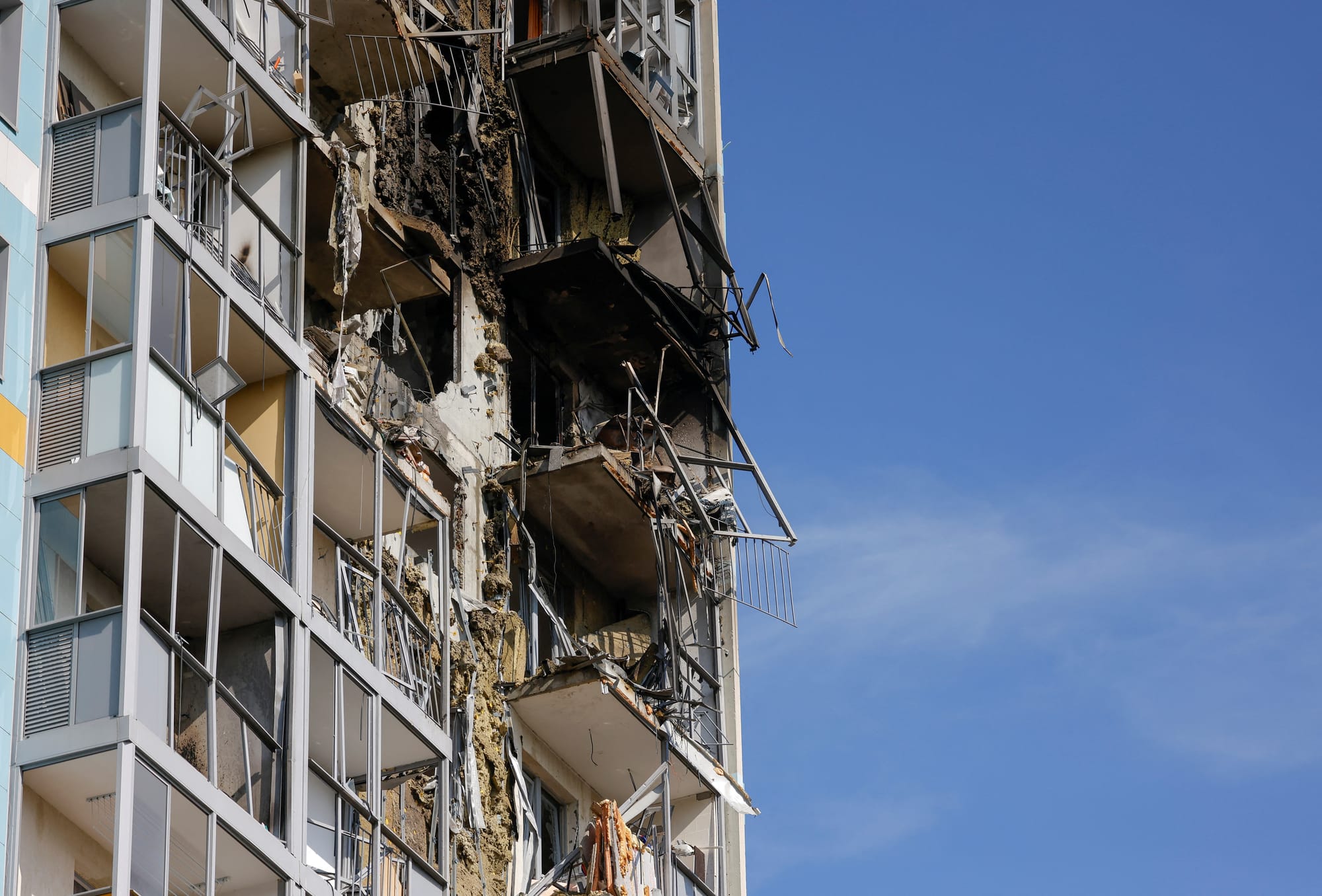 Blackened, burned-out facade of a multi-storey building near a fuel and energy facility after drone debris struck.
