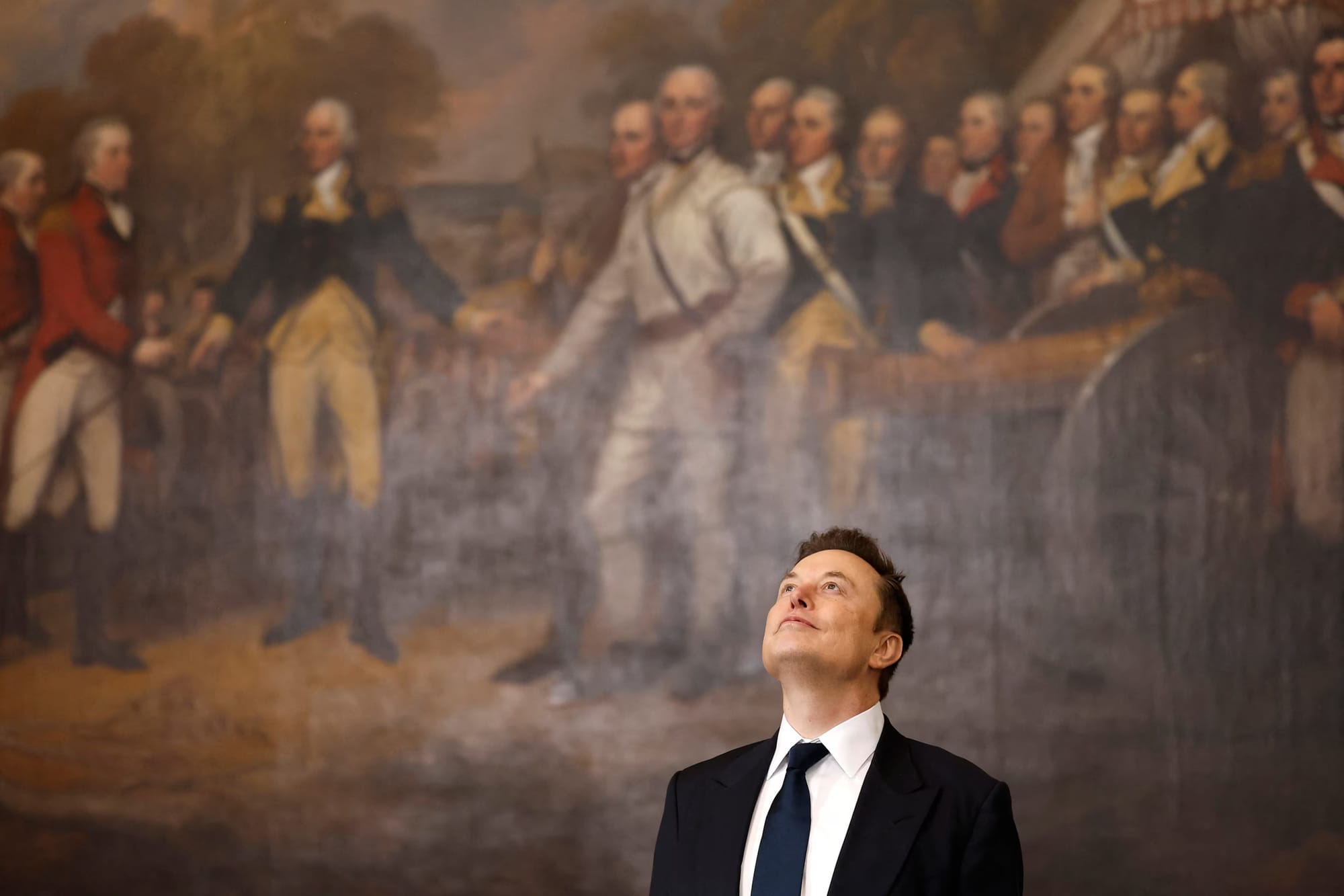 Elon Musk gazes upward beneath a historic American battle painting, symbolizing his rising influence and ambitions in politics and history.