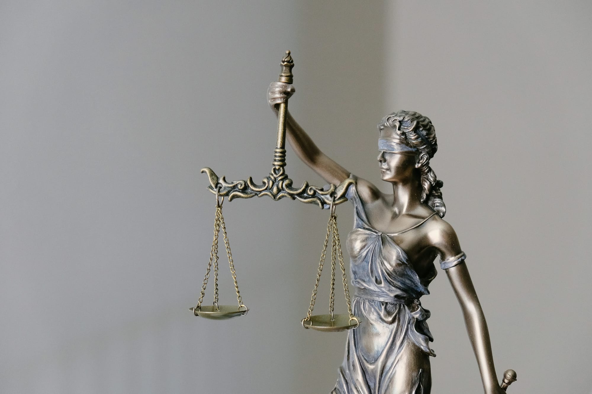 Bronze scales of justice on a polished courtroom desk