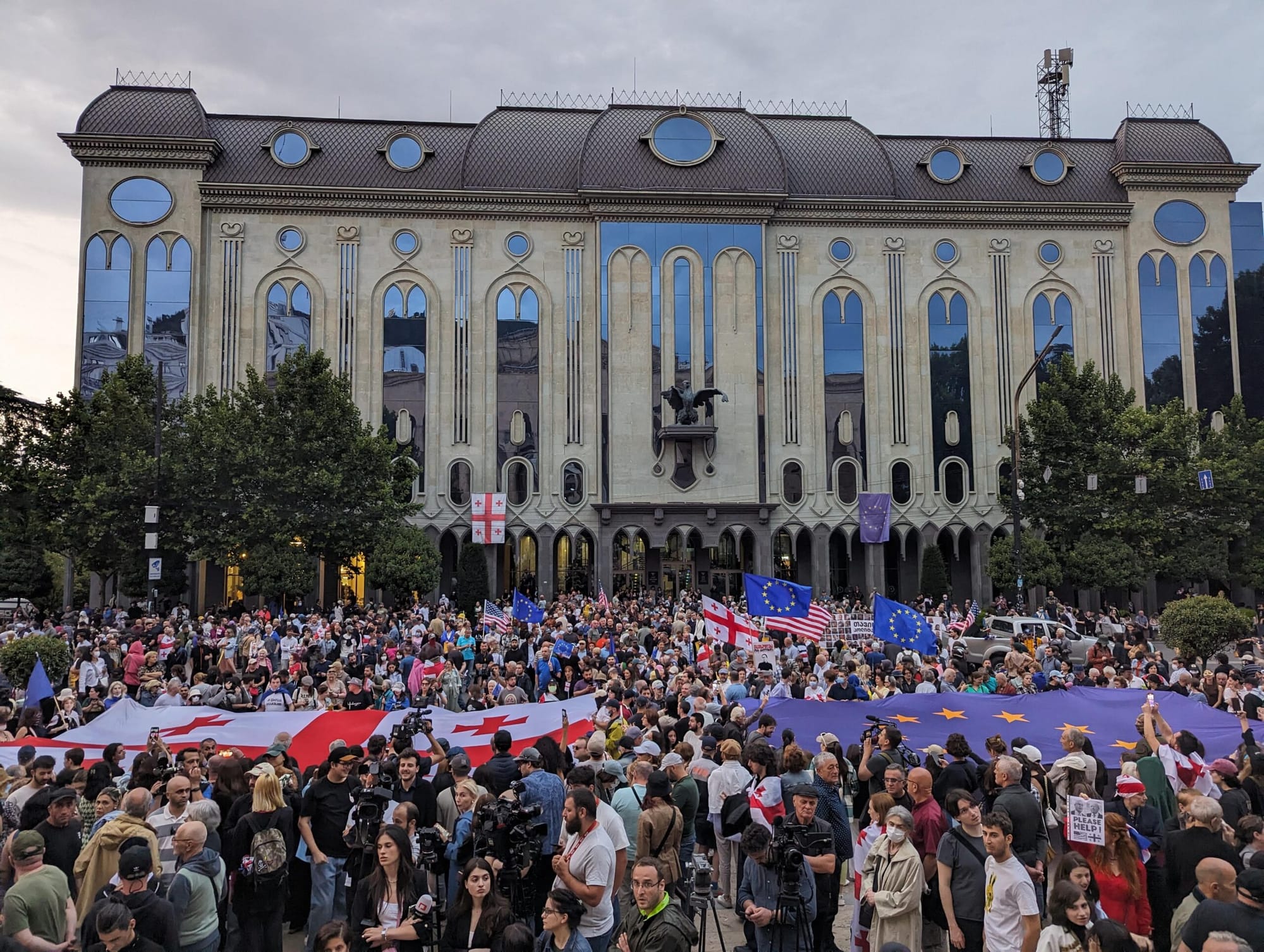 Thousands of people gather in front of the Georgian Parliament in Tbilisi holding Georgian and EU flags during an anti-government demonstration.