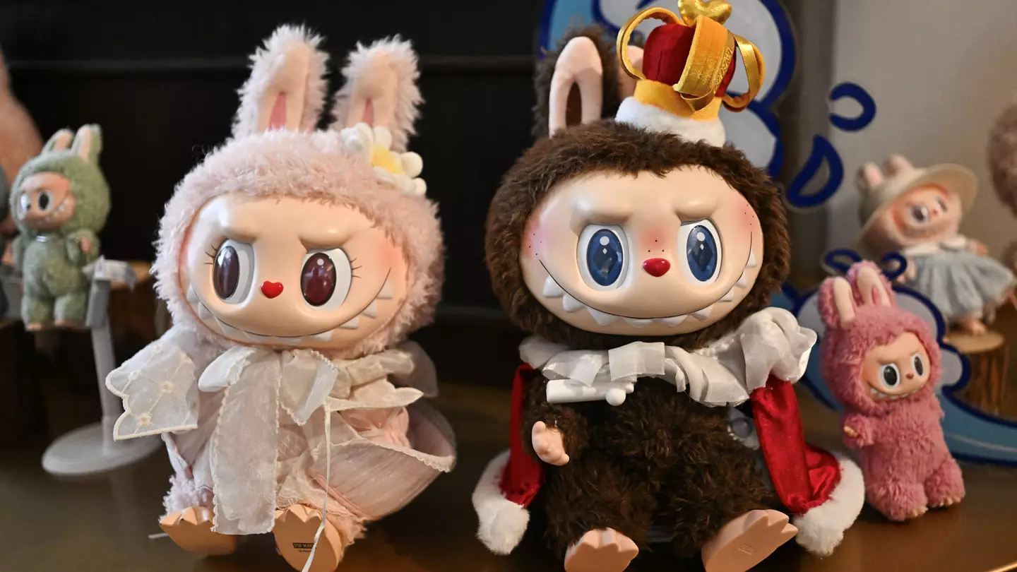 Multiple Labubu plush toys lined up on a retail shelf, showing a variety of colors and expressions.