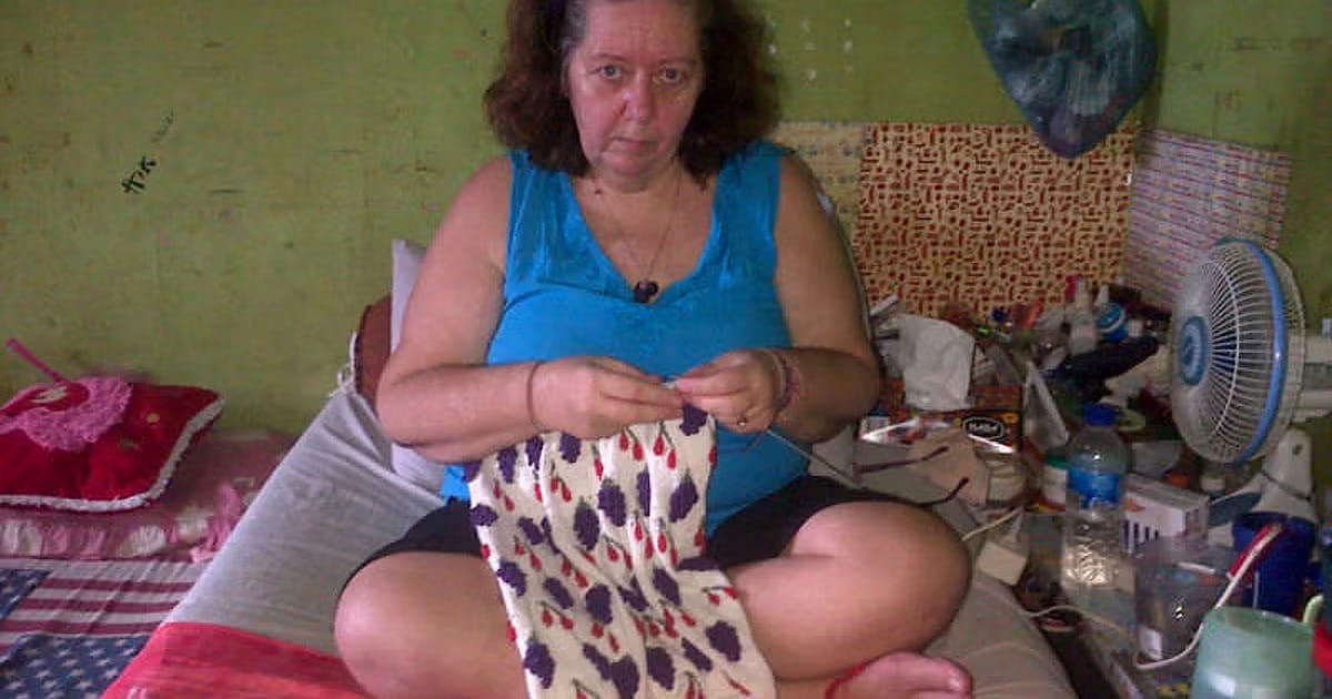 British grandmother Lindsay Sandiford sitting on a bed in a prison cell, crocheting.