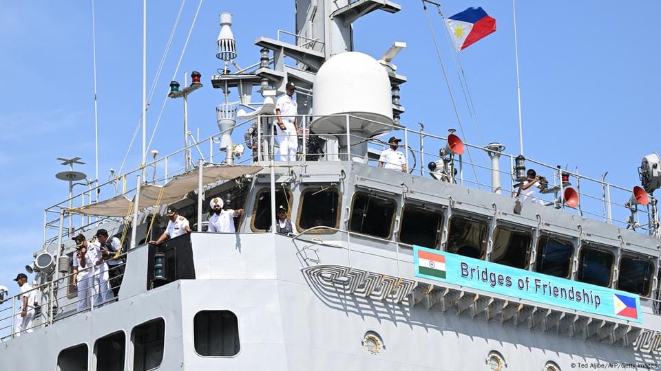 Indian Navy personnel aboard a warship participating in a naval exercise with the Philippines, with the banner “Bridges of Friendship” and both nations' flags prominently displayed.