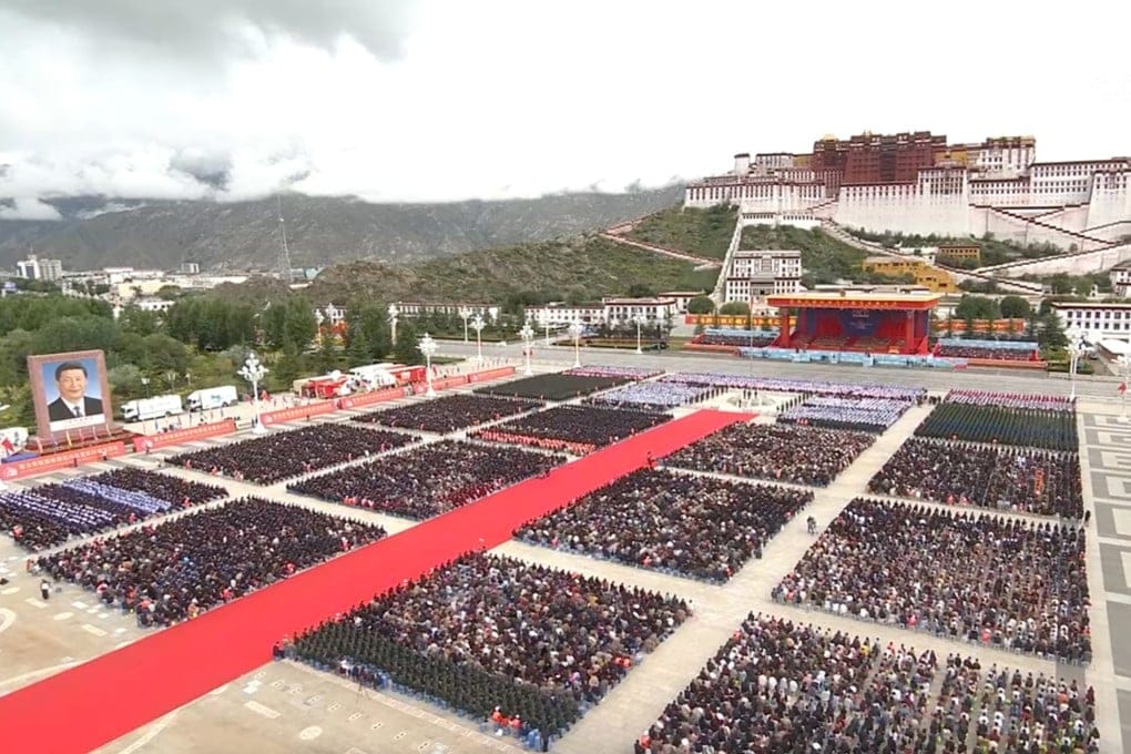 Large crowds gather in Lhasa’s Potala Palace Square for a celebration, with a giant portrait of Xi Jinping displayed and the historic Potala Palace in the background.