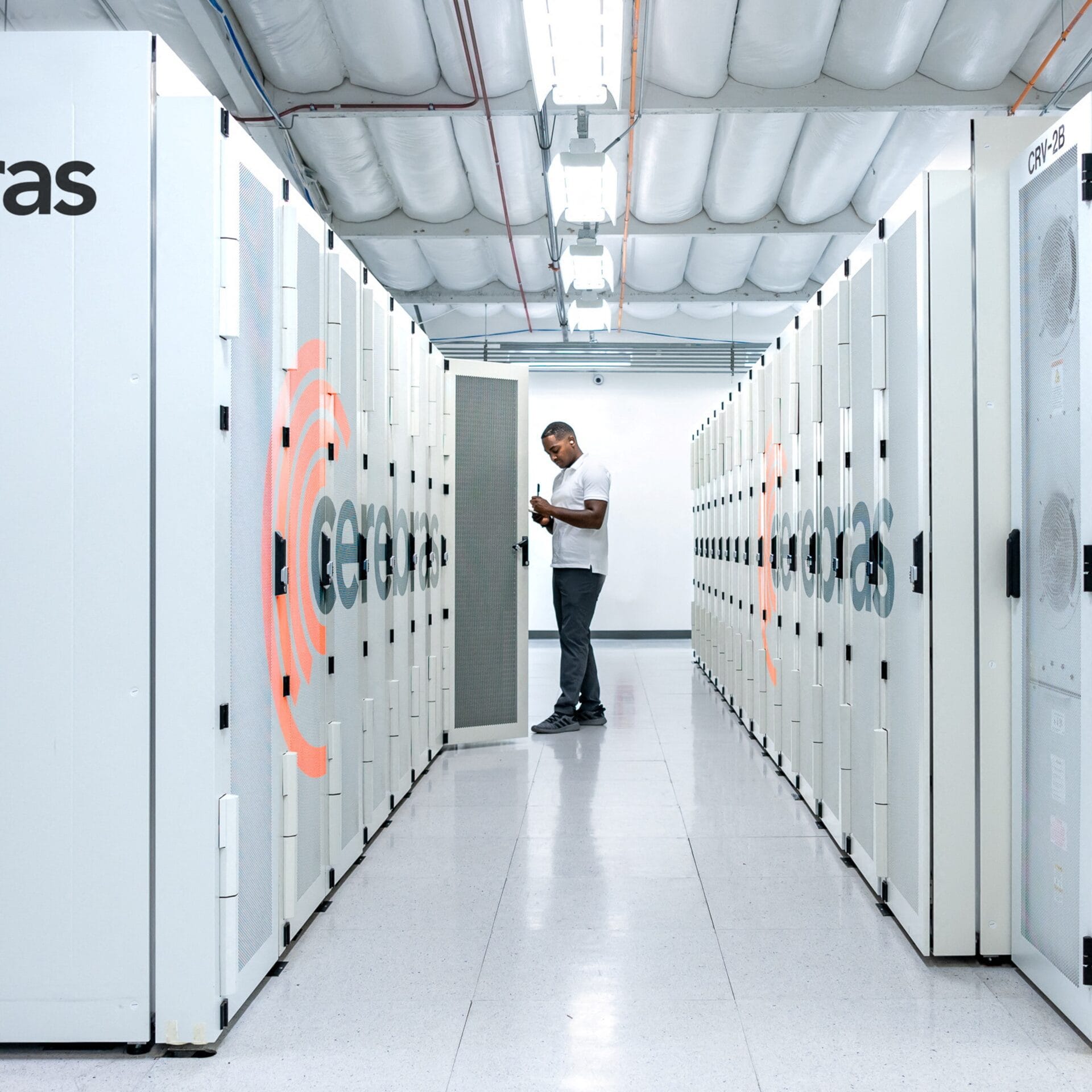Technician working inside a modern AI data center, surrounded by rows of high-performance servers used for artificial intelligence workloads.