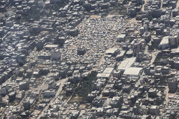 Aerial view of densely populated neighborhoods and temporary shelters in Gaza City amid ongoing conflict.