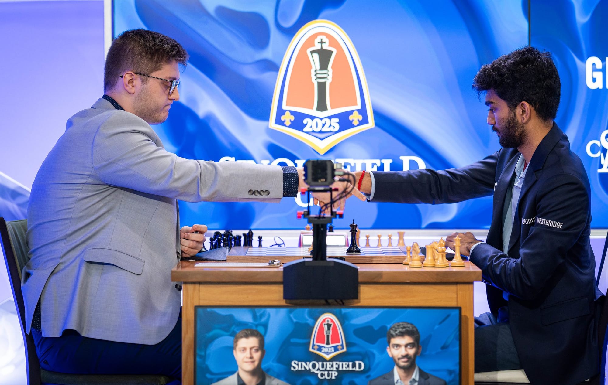 Chess players shaking hands before a Sinquefield Cup 2025 match, with the tournament logo displayed in the background.