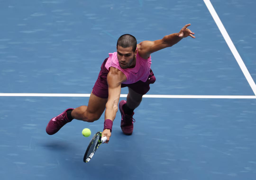 Alcaraz in action, diving for a return.