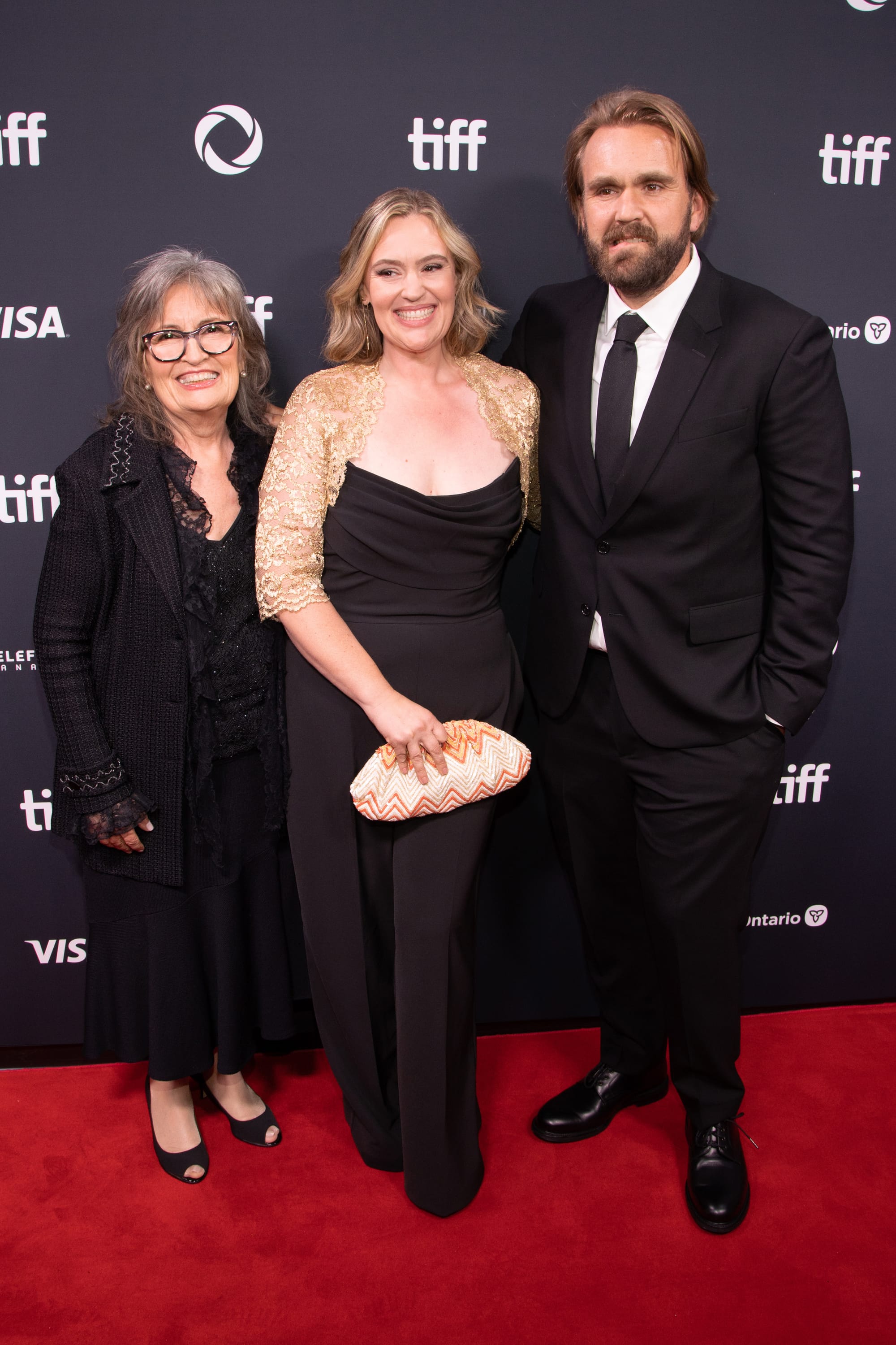 Smiles and style at TIFF, as this trio embraces the red carpet in timeless black-and-gold ensembles.