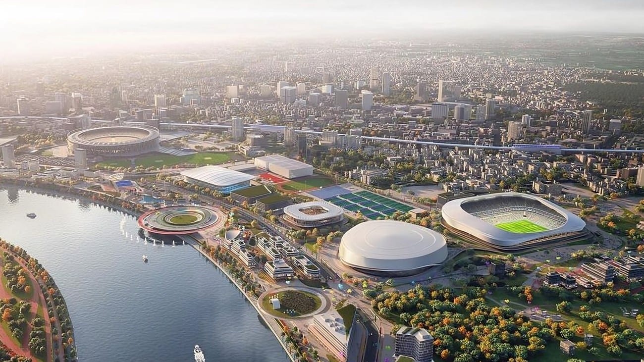 A grand architectural photo (likely of India’s planned venue) highlighting the scale and infrastructure that could support the Games.