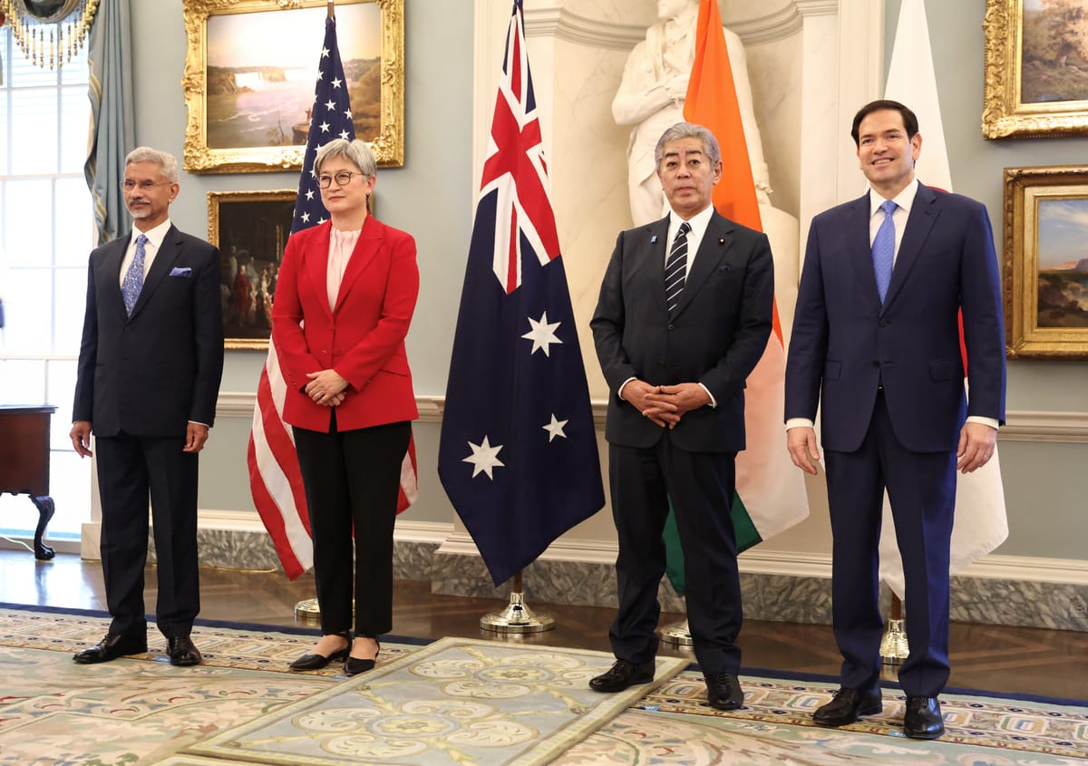 The full delegation standing in front of national flags