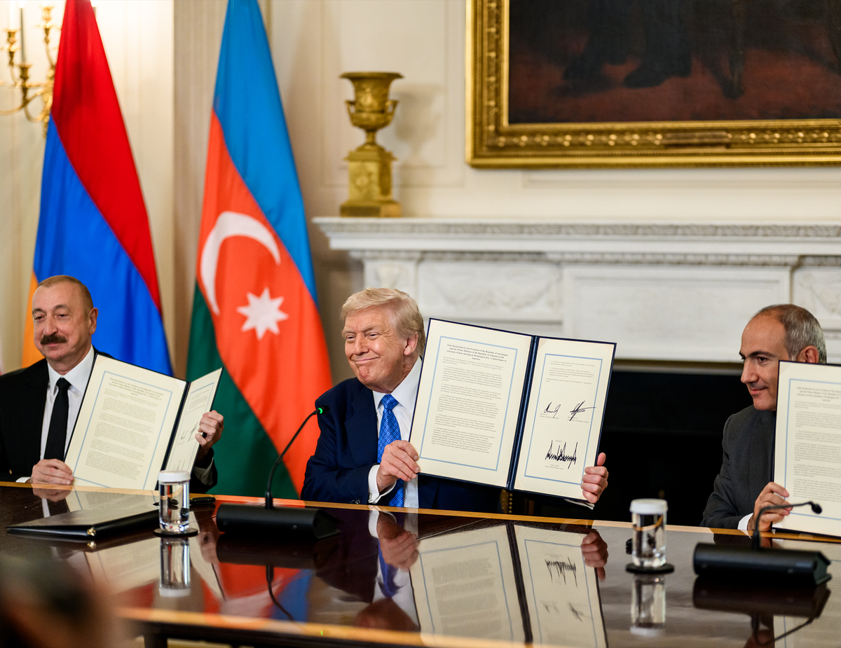 Azerbaijani President Ilham Aliyev, U.S. President Donald Trump, and Armenian Prime Minister Nikol Pashinyan display signed peace agreement documents at a White House ceremony.