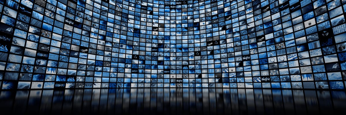 A large curved digital video wall displaying hundreds of blue-tinted thumbnail images, symbolizing media, entertainment, and digital content streaming.