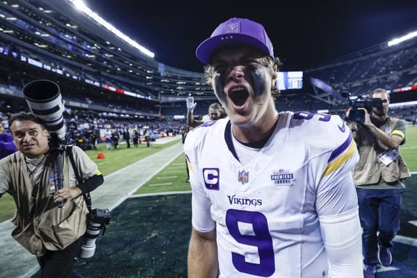 NFL player from the Minnesota Vikings celebrating passionately on the field after a game.